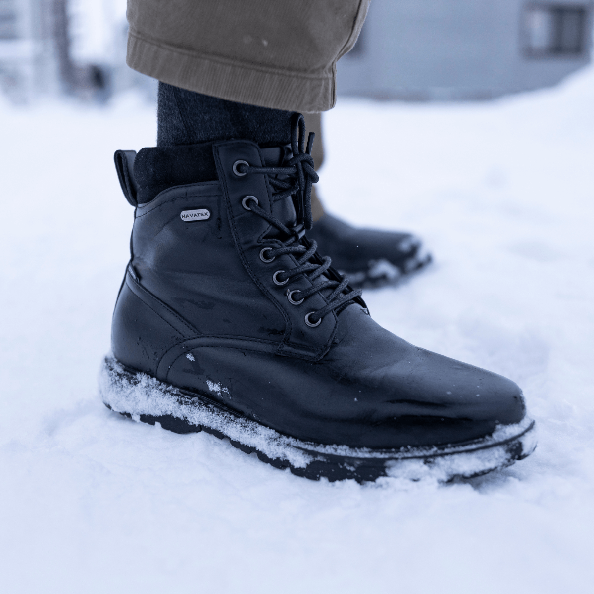 Black winter boots on a snowy ground
