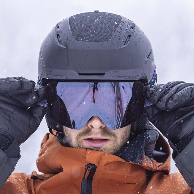 Person wearing a helmet and goggles in a snowy environment