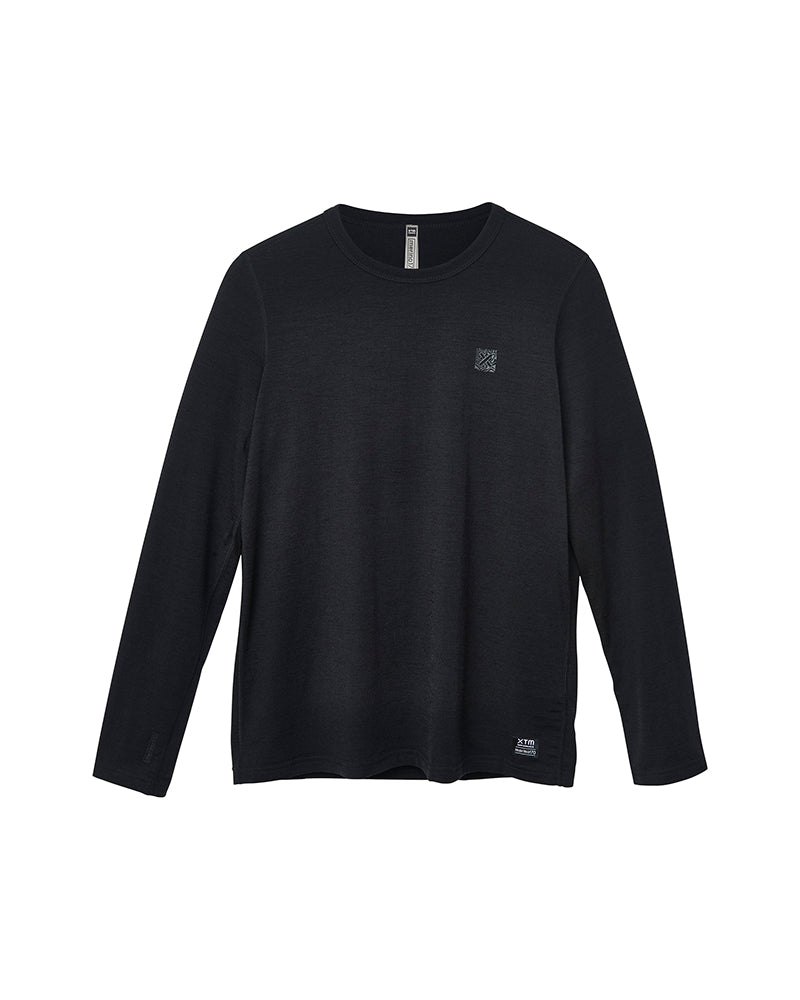 A black long-sleeve crewneck knit top with a small tonal logo on the left chest and a small white logo near the lower hem, displayed on a solid white background. XTM women women's wool merino thermal base layer snow ski cold