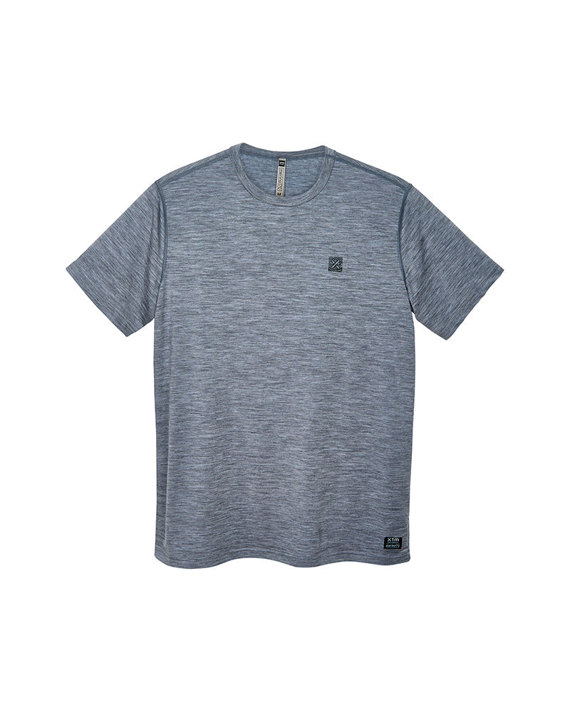 A heather gray short-sleeve crewneck athletic t-shirt with a small black square logo on the left chest and a small black logo patch near the bottom hem, displayed on a solid white background. Grey XTM icon merin wool tencel base layer t-shirt